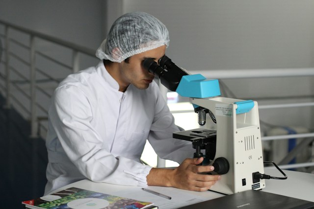 a man looking in a microscope photo