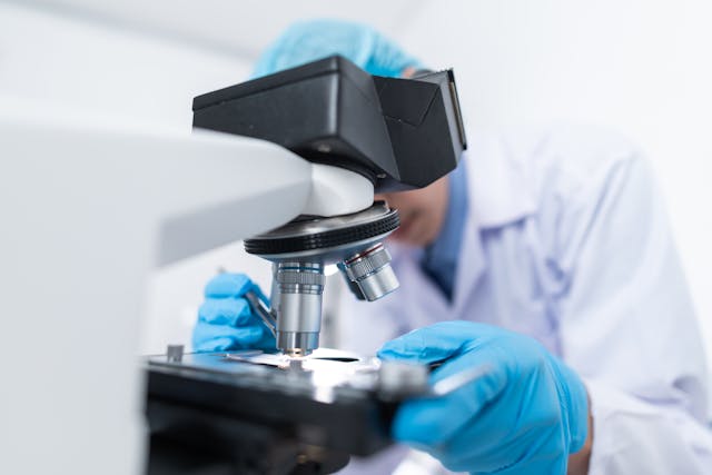 a man looking in a microscope photo